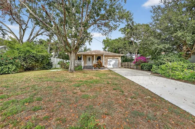 a front view of a house with a yard and trees