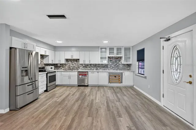 a kitchen with stainless steel appliances granite countertop a refrigerator sink and cabinets