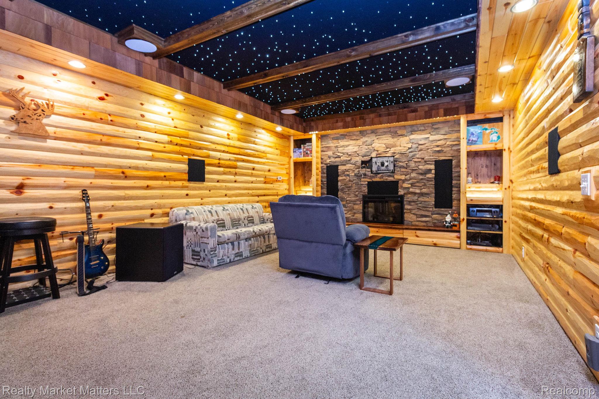 770 North Fairgrounds Road Imlay City, MI 48444 - Photo 36 of 55 Wood-paneled room featuring a stone-faced fireplace with built-in shelving, recessed lighting, and a starlight-effect ceiling