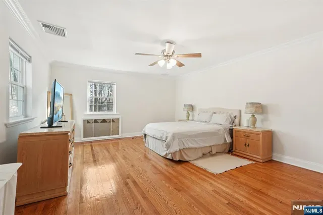 a spacious bedroom with a bed and a table with wooden floor