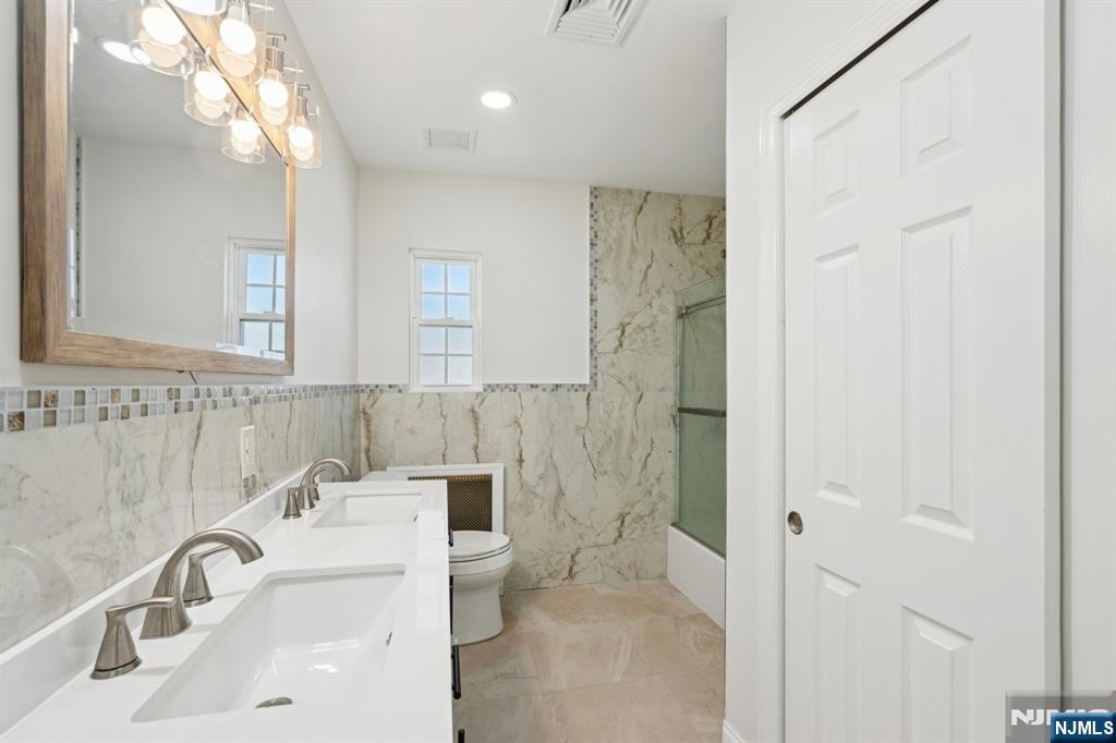 1486 Windsor Road Teaneck, NJ 07666 - Photo 16 of 24 a bathroom with a sink a toilet and shower