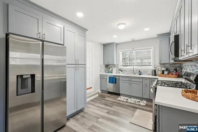a kitchen with a refrigerator and white cabinets