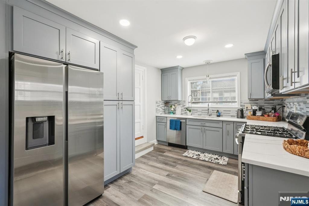 1486 Windsor Road Teaneck, NJ 07666 - Photo 5 of 24 a kitchen with a refrigerator and white cabinets