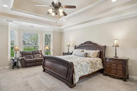 a bedroom with a bed and a flat tv screen on dresser