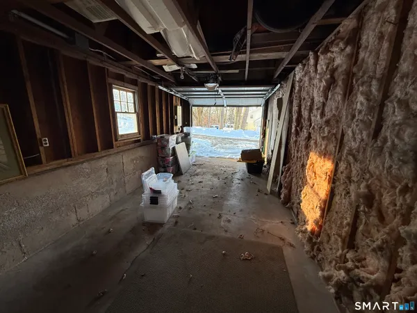 a view of an empty room with wooden floor and windows