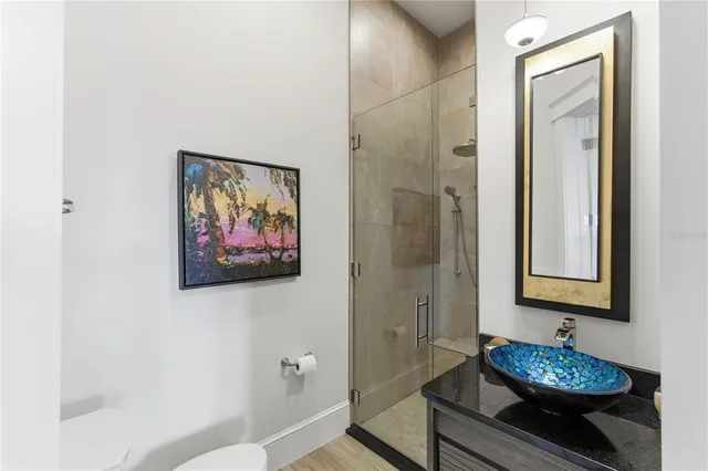 a bathroom with a granite countertop sink toilet and shower