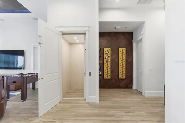 a kitchen with stainless steel appliances granite countertop a table chairs wooden floors and a view of living room