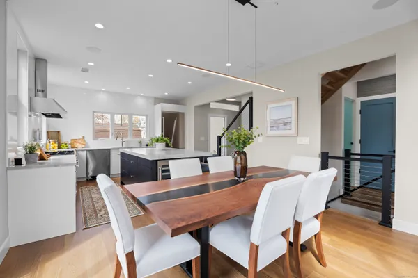 a kitchen with a dining table chairs and refrigerator