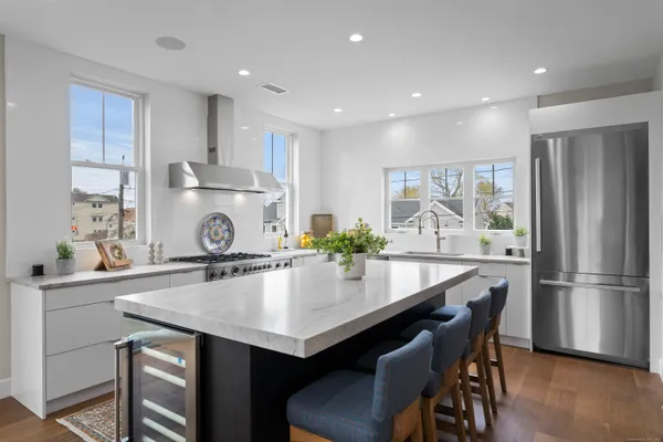 a kitchen with kitchen island a table chairs stove and refrigerator