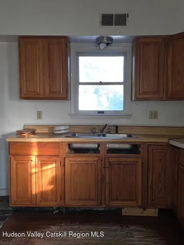 a kitchen with stainless steel appliances granite countertop wooden cabinets a stove and a sink