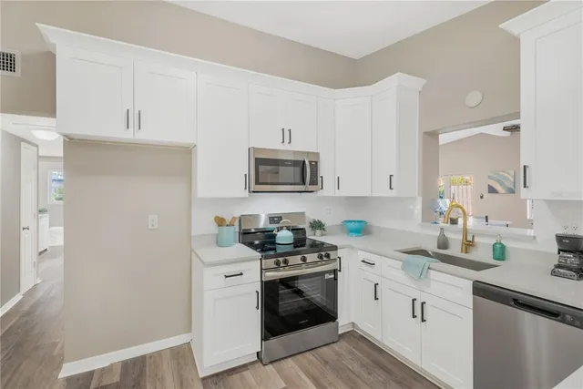 a kitchen with white cabinets and stainless steel appliances