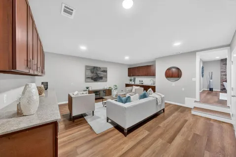 a living room with furniture and a wooden floor