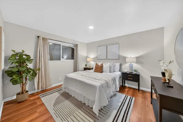 a bedroom with a bed and a potted plant