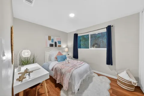 a bedroom with a bed and wooden floor