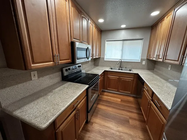 a kitchen with kitchen island granite countertop a sink stove and cabinets