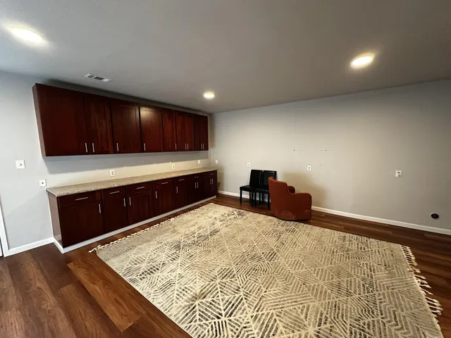a kitchen with wooden floors and wooden cabinets