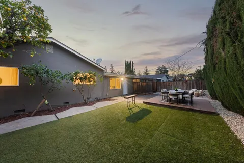 a view of a house with backyard and sitting area
