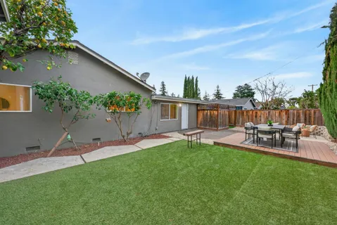 a view of a house with backyard and sitting area