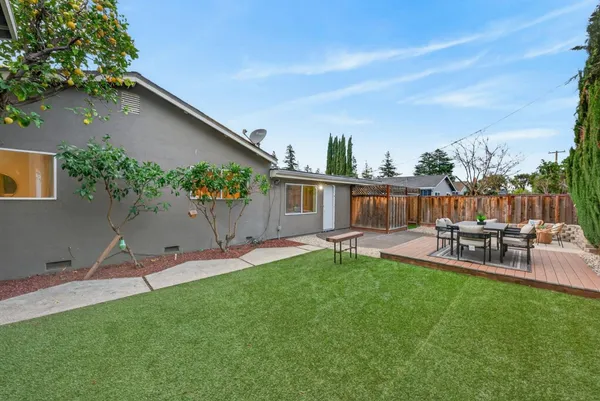 a view of a house with backyard and sitting area