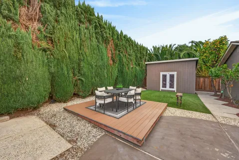 a view of a patio with a table and chairs with wooden fence