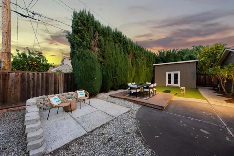 a backyard of a house with table and chairs