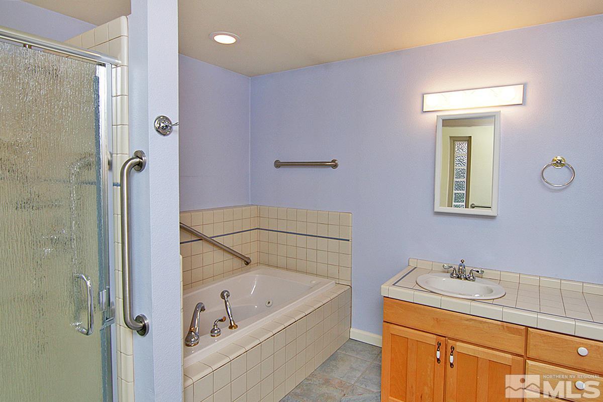 560 Citadel Road Reno, NV 89503 - Photo 13 of 25 a bathroom with a tub sink and mirror