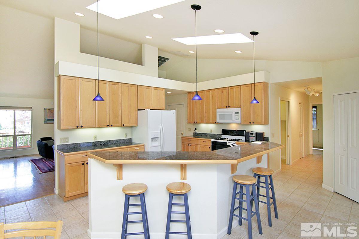 560 Citadel Road Reno, NV 89503 - Photo 17 of 25 a kitchen with a sink a stove a refrigerator and white cabinets with wooden floor
