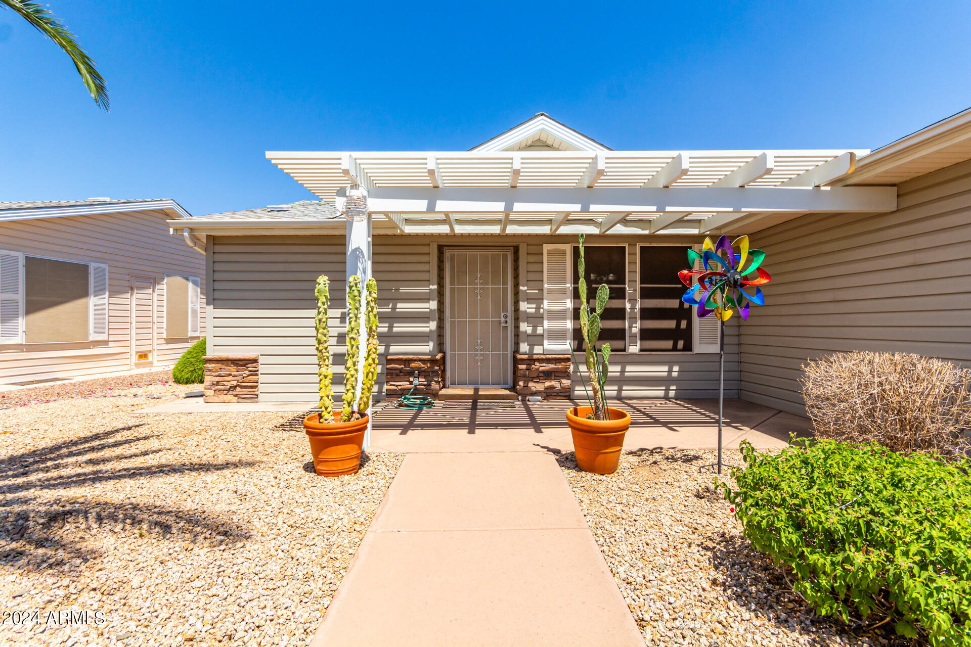 2550 South Ellsworth Road, Unit 366 Mesa, AZ 85209 - Photo 4 of 27 a view of a patio with table and chairs under an umbrella
