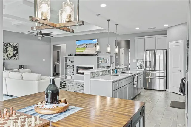 a kitchen with stainless steel appliances kitchen island granite countertop a dining table and chairs