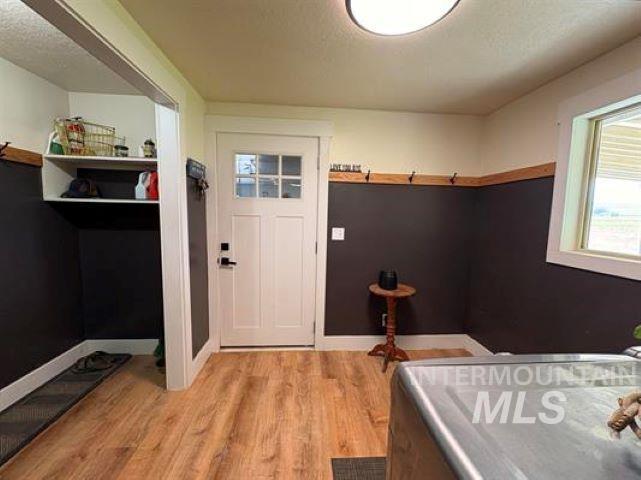 3197 Neeley Road American Falls, ID 83211 - Photo 10 of 45 Entryway featuring wood-finish flooring, a white paneled door with integrated window panes, and a built-in storage cubby with shelving
