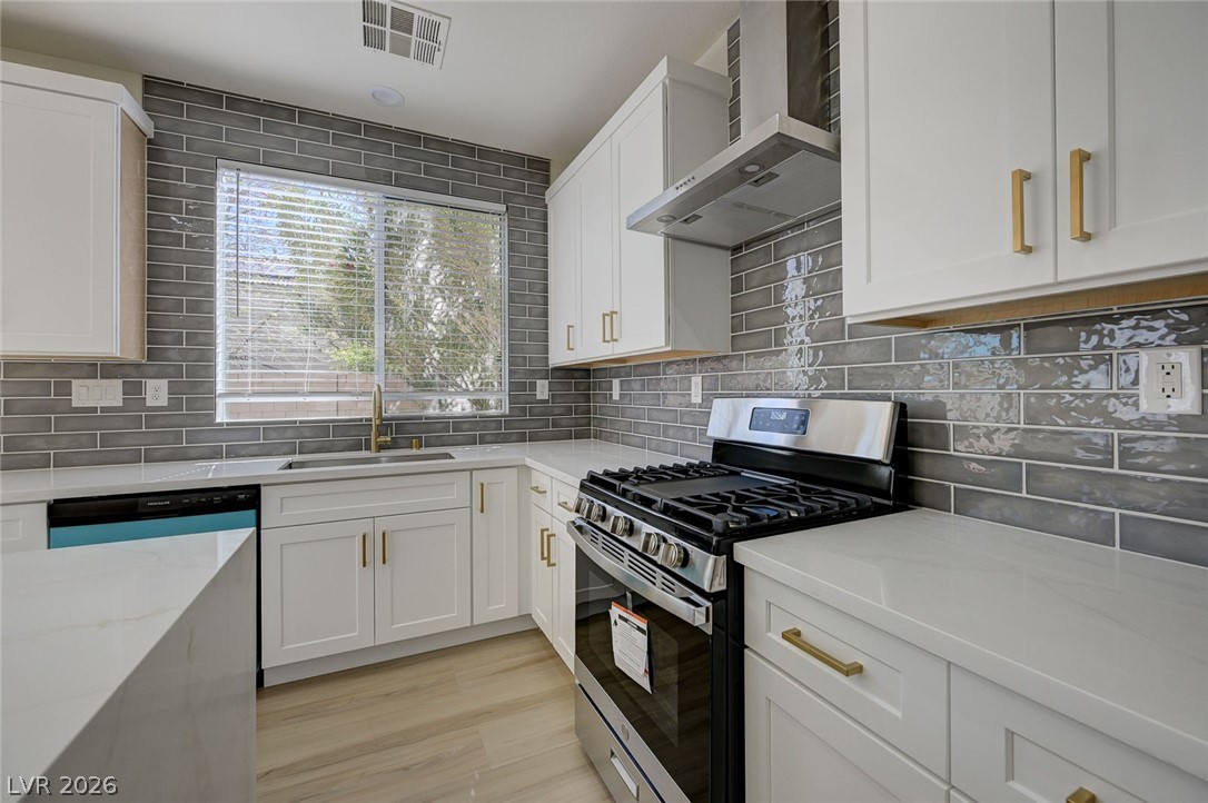 9687 Ridgebluff Avenue Las Vegas, NV 89148 - Photo 12 of 57 Kitchen with gas stove, light stone counters, white cabinets, and light wood-style floors