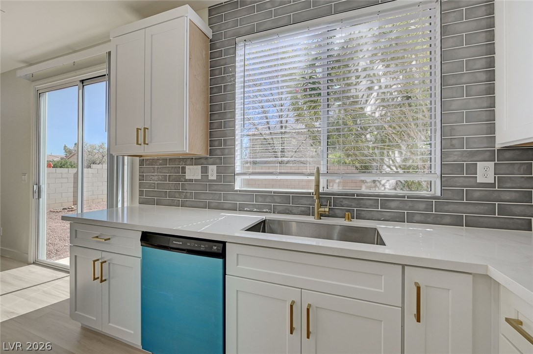 9687 Ridgebluff Avenue Las Vegas, NV 89148 - Photo 13 of 57 Kitchen with dishwasher, white cabinetry, light stone counters, and light wood finished floors
