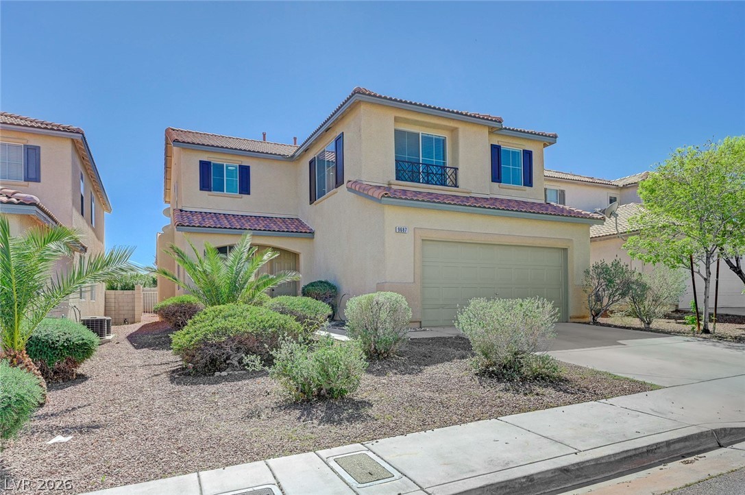9687 Ridgebluff Avenue Las Vegas, NV 89148 - Photo 2 of 57 Mediterranean / spanish house featuring a garage, concrete driveway, a tiled roof, stucco siding, and a balcony