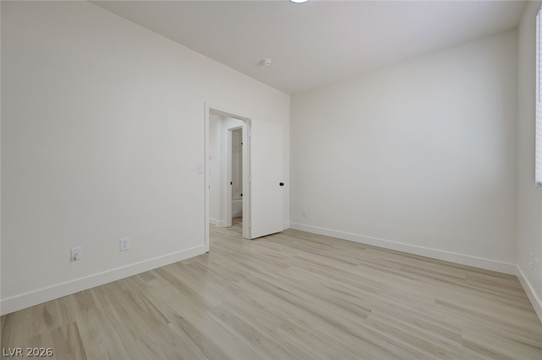 9687 Ridgebluff Avenue Las Vegas, NV 89148 - Photo 29 of 57 Empty room featuring light wood-style floors and baseboards