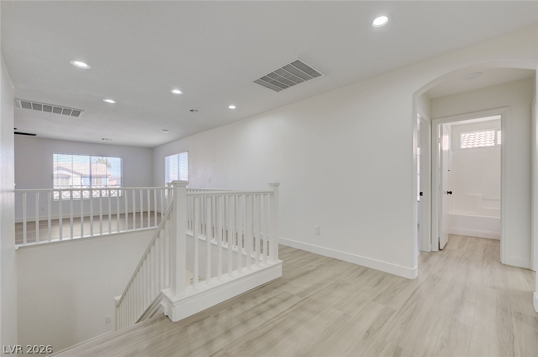 9687 Ridgebluff Avenue Las Vegas, NV 89148 - Photo 31 of 57 Hall featuring an upstairs landing, arched walkways, light wood-style floors, and recessed lighting