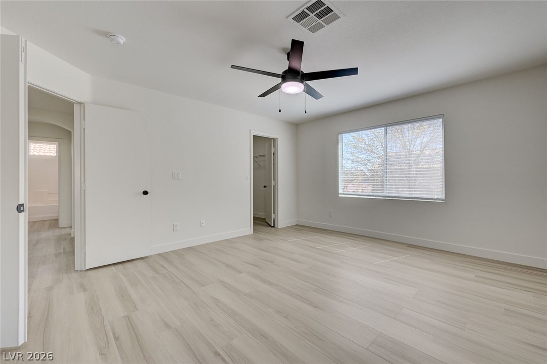 9687 Ridgebluff Avenue Las Vegas, NV 89148 - Photo 33 of 57 Unfurnished bedroom with light wood-style floors, a walk in closet, and ceiling fan