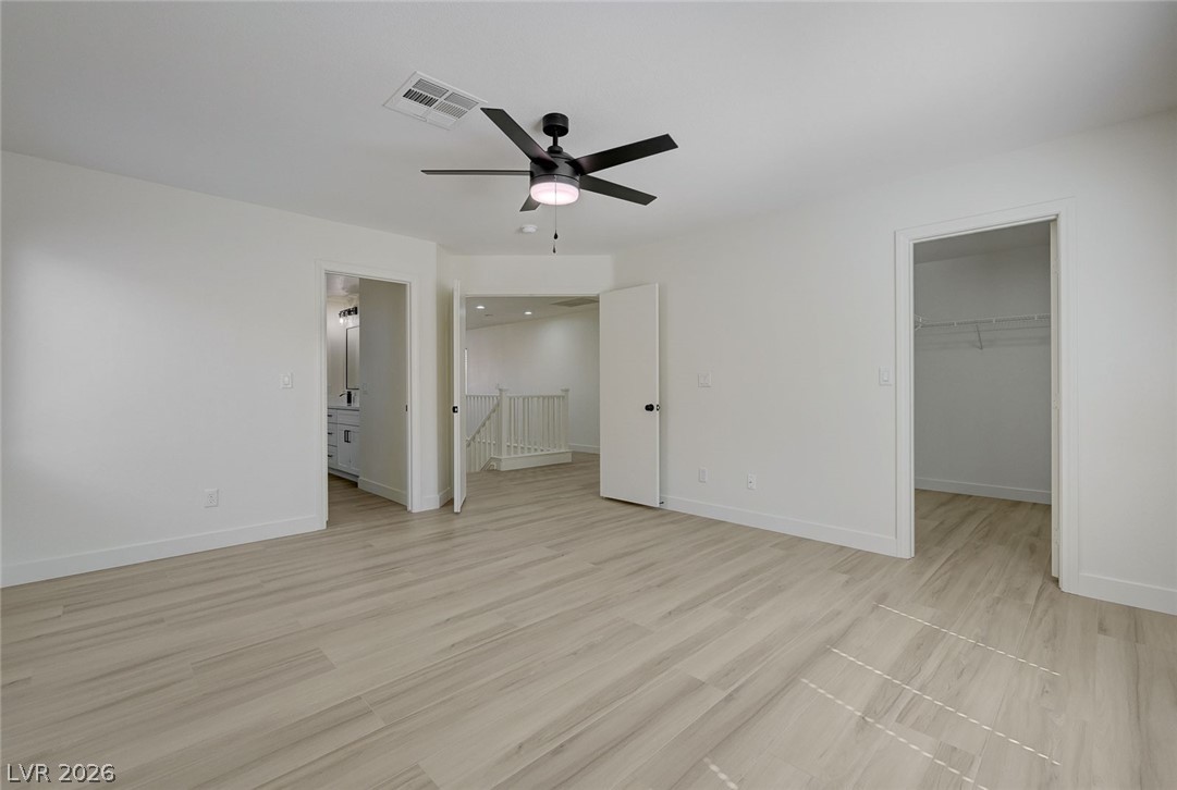 9687 Ridgebluff Avenue Las Vegas, NV 89148 - Photo 34 of 57 Unfurnished bedroom with a walk in closet, light wood finished floors, ceiling fan, and connected bathroom