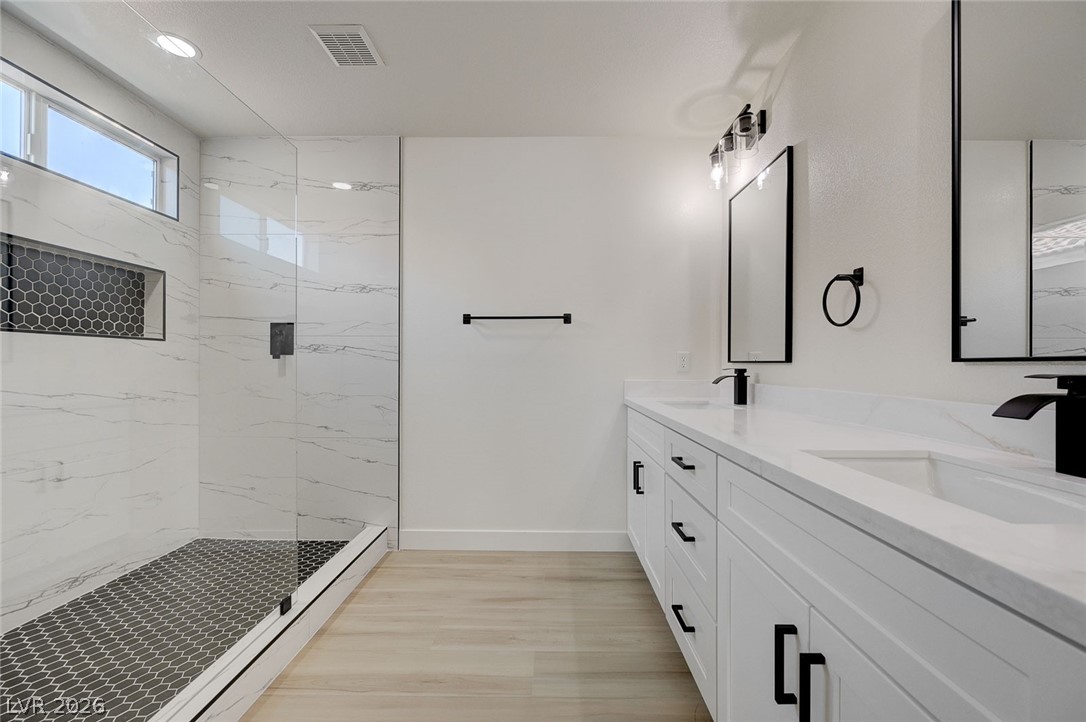 9687 Ridgebluff Avenue Las Vegas, NV 89148 - Photo 36 of 57 Full bathroom featuring double vanity, a marble finish shower, and light wood-style flooring