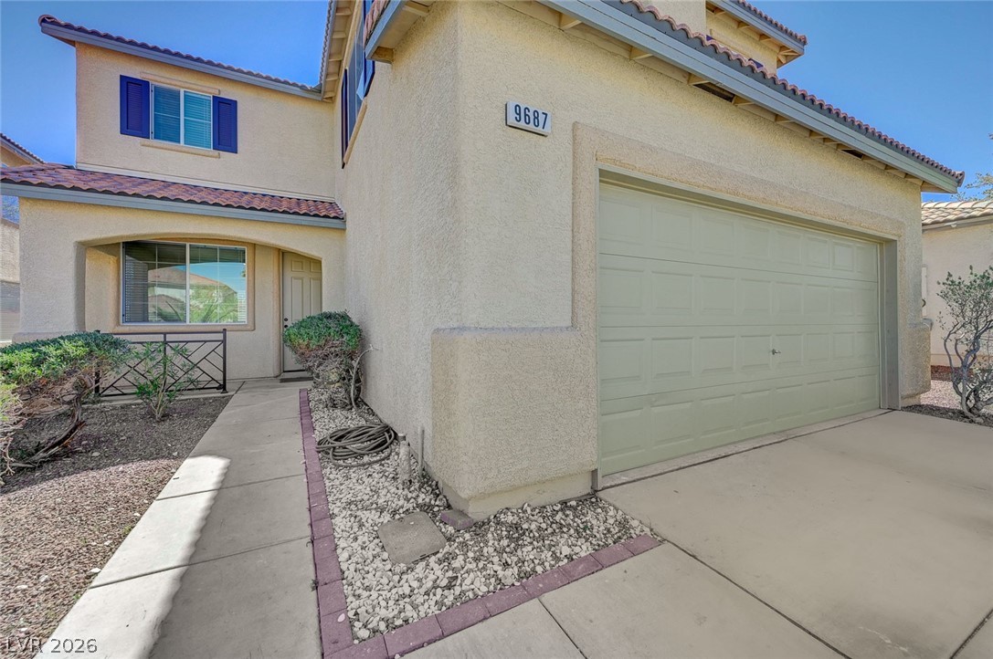 9687 Ridgebluff Avenue Las Vegas, NV 89148 - Photo 4 of 57 View of front of property with a tiled roof, driveway, and stucco siding