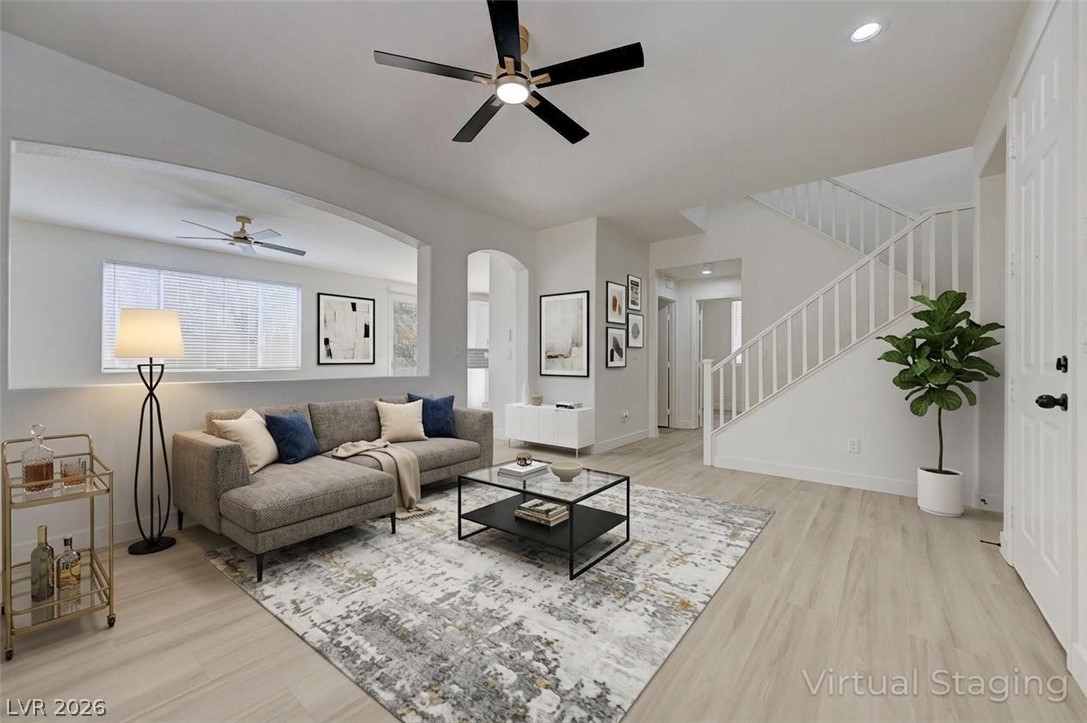 9687 Ridgebluff Avenue Las Vegas, NV 89148 - Photo 6 of 57 Living room with ceiling fan, light wood-style floors, and arched walkways