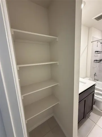 a view of walk in closet with empty racks