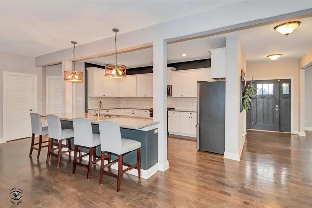 a kitchen with stainless steel appliances kitchen island granite countertop a refrigerator and a dining table