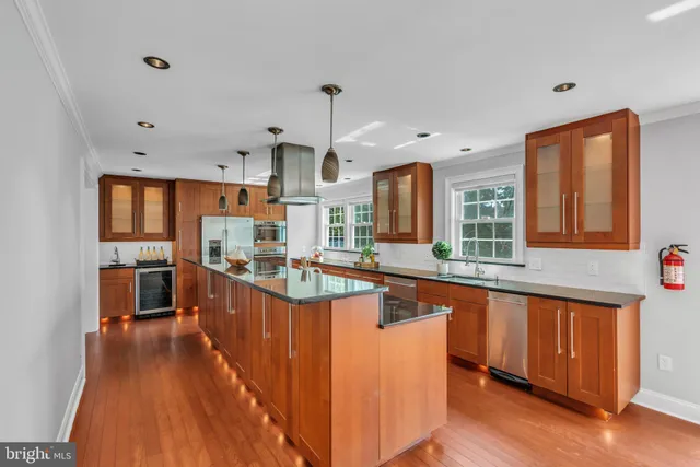a large kitchen with stainless steel appliances granite countertop a stove and a sink