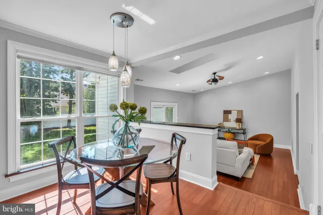a dining room with furniture a chandelier and wooden floor