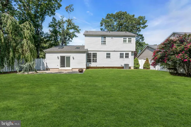 a view of a house with a yard deck and a small yard