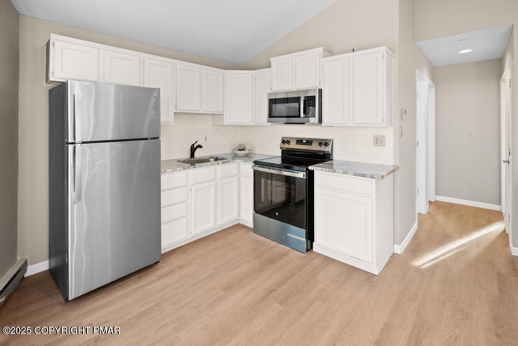 136 Netcong Circle Pocono Lake, PA 18347 - Photo 29 of 40 a kitchen with white cabinets and stainless steel appliances