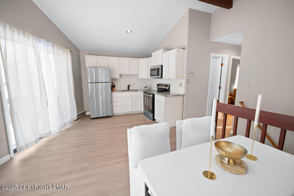 136 Netcong Circle Pocono Lake, PA 18347 - Photo 34 of 40 a kitchen with stainless steel appliances kitchen island granite countertop a dining table chairs and a refrigerator