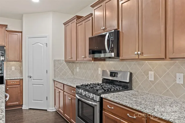 a kitchen with kitchen island a counter top space a sink stainless steel appliances and a counter top space