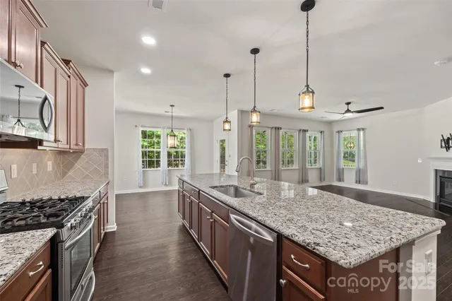 a kitchen with granite countertop a sink and dishwasher with wooden floor