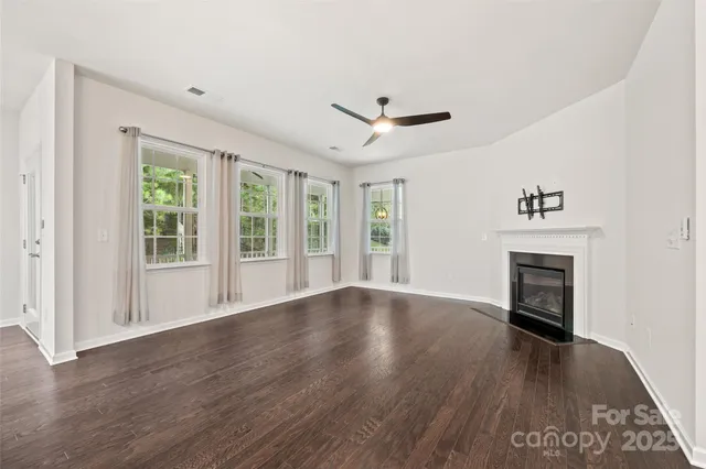 a view of a room with wooden floor and a kitchen